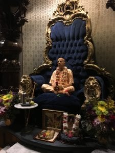 Prabhubpada, located in the temple, with offerings at the base of his chair.